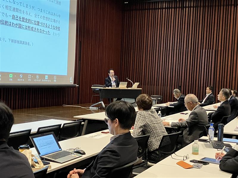 プロジェクターを使って説明する講演者